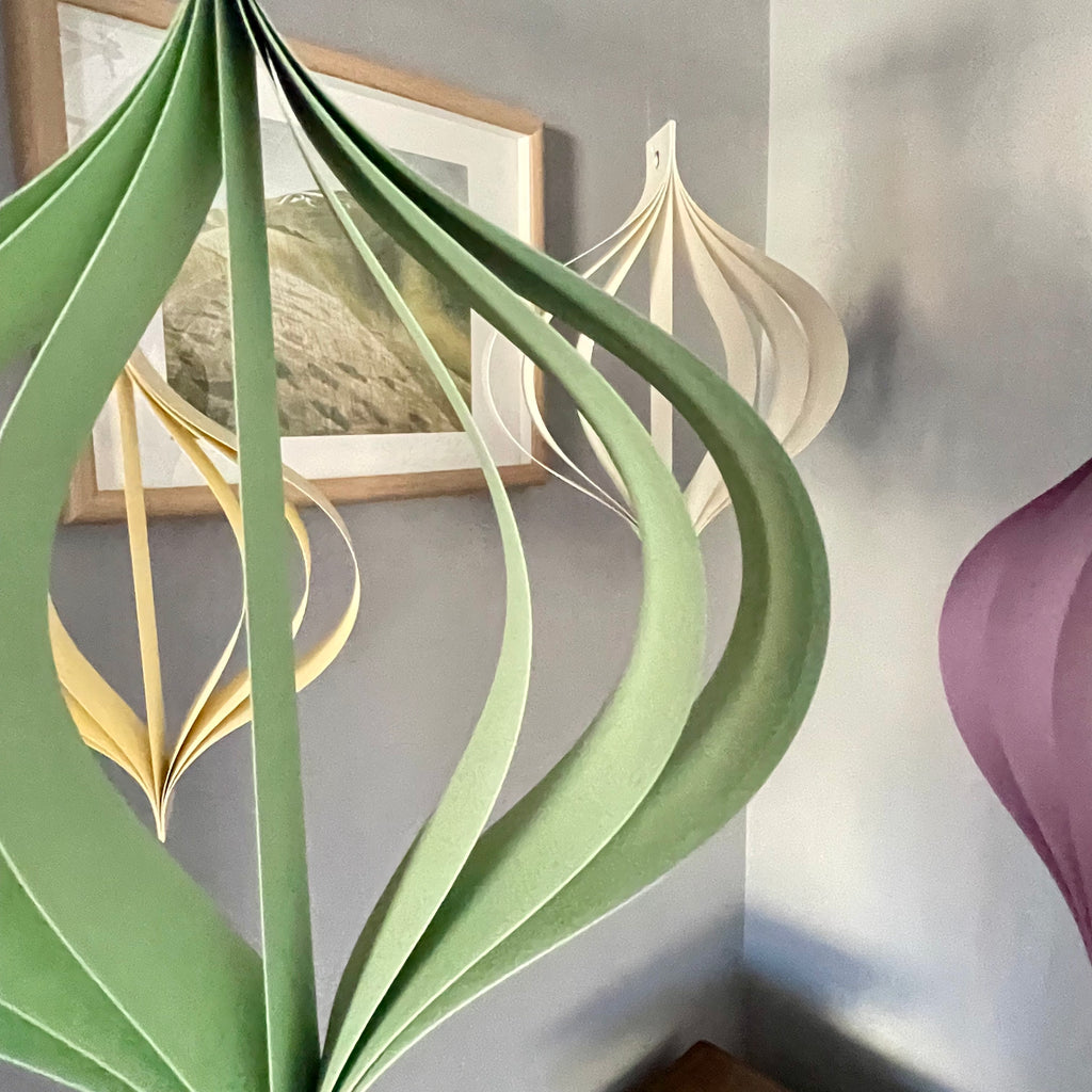 Pastel home ornaments in dusty pastel tones of green, yellow, beige, blue and purple on a neutral background