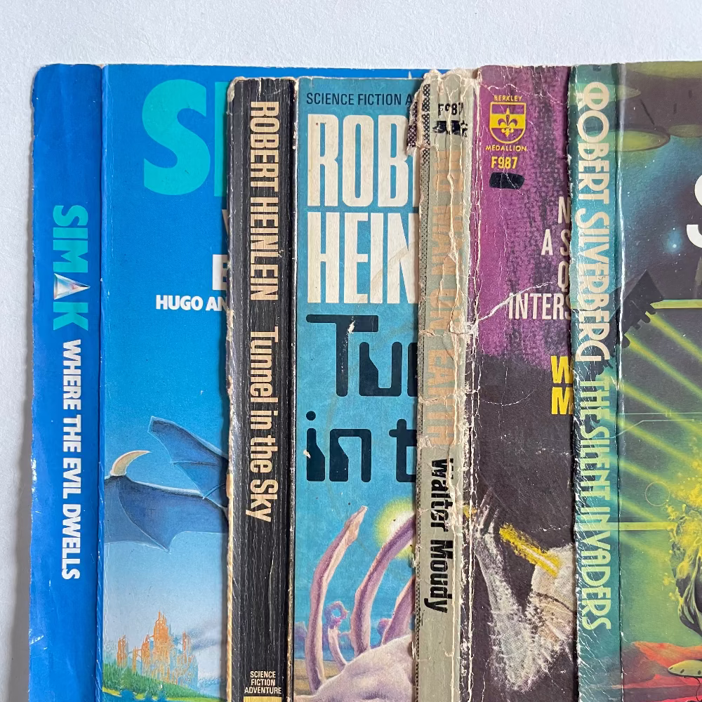 Collection of science fiction books with visible titles and authors on a white background