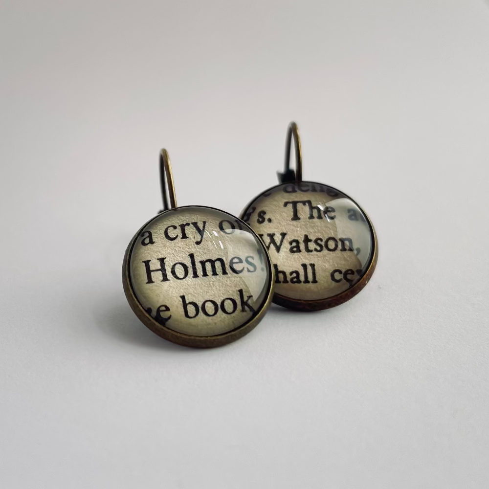 Pair of earrings with text on a white background. They read Holmes and Watson