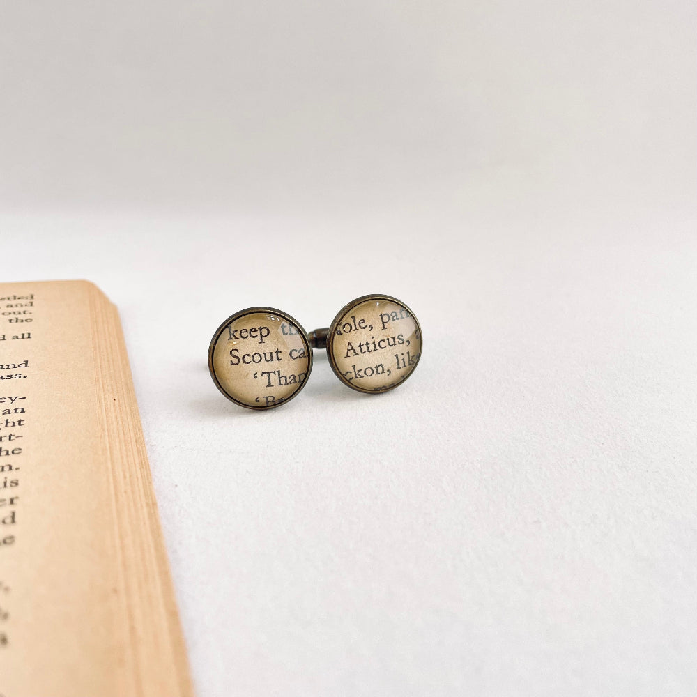 to kill a mockingbird book cufflinks with text on a white background