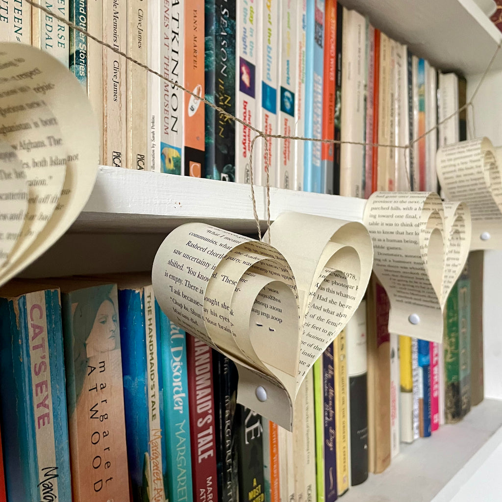 Decorative paper heart garland on a bookshelf with books in the background