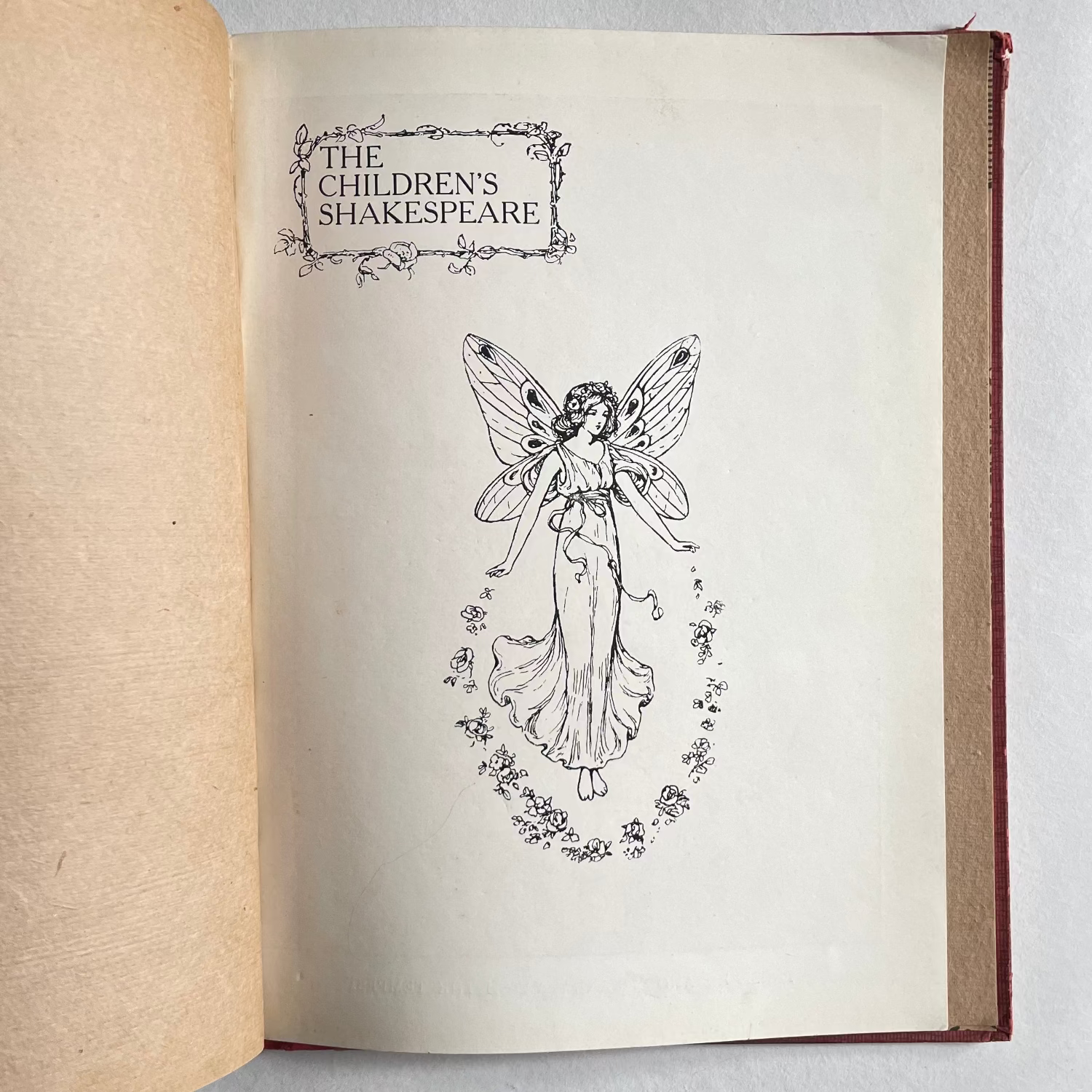 Open book with illustration of a fairy from 'The Children's Shakespeare' on a white background