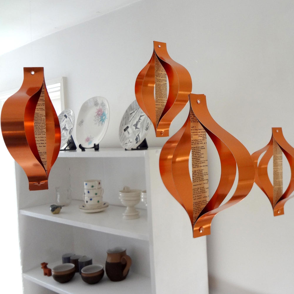 A set of copper metallic Christmas decorations with a mid-century design, displayed against a light background.