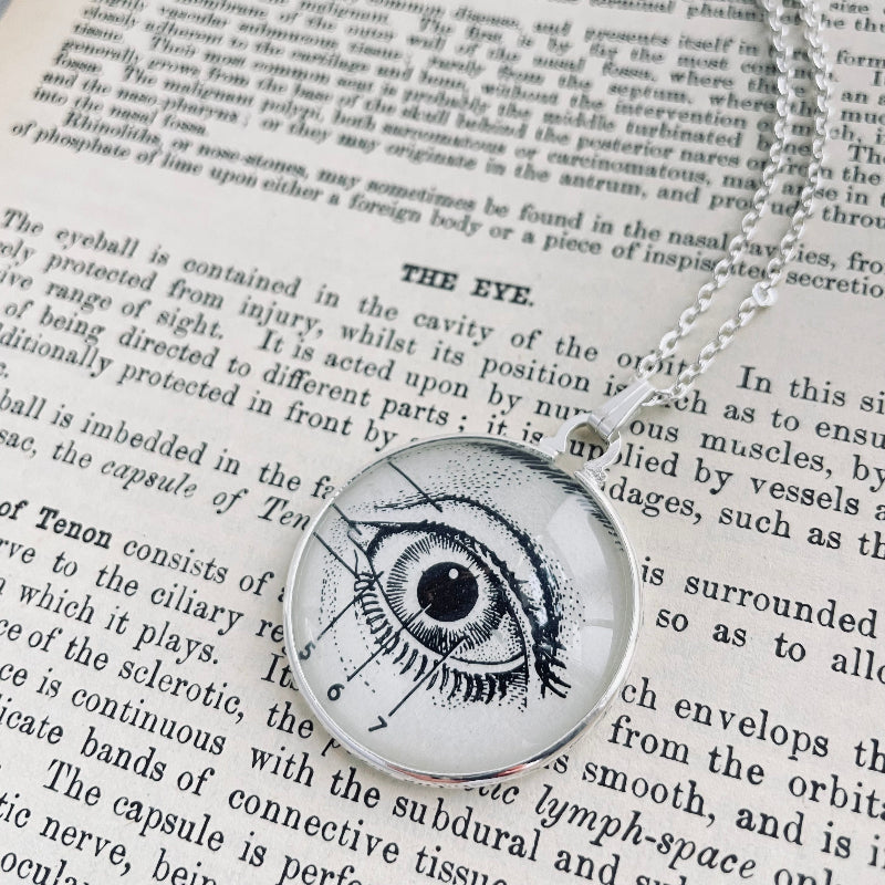 Eyeball pendant necklace on an open book