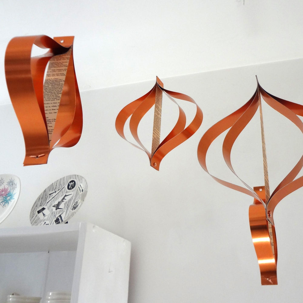 A set of copper metallic Christmas decorations with a mid-century design, displayed against a light background.