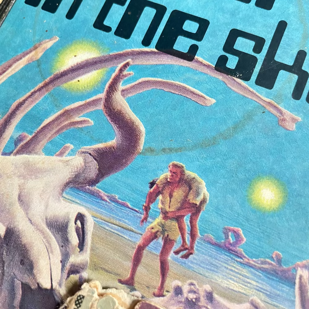 Vintage-style illustration of a man interacting with a large skeleton on a beach.