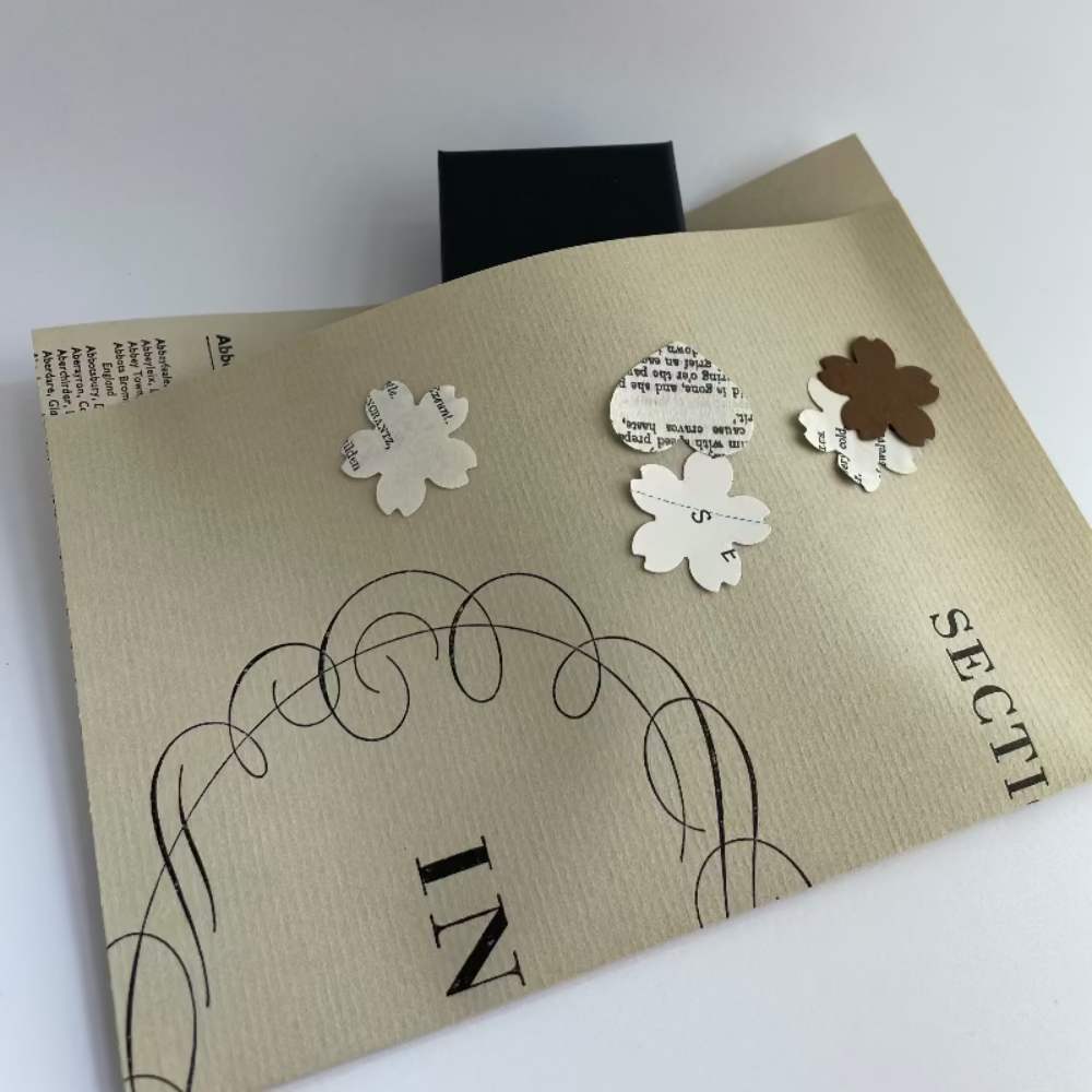 earring box in a book page envelope with scattered book confetti