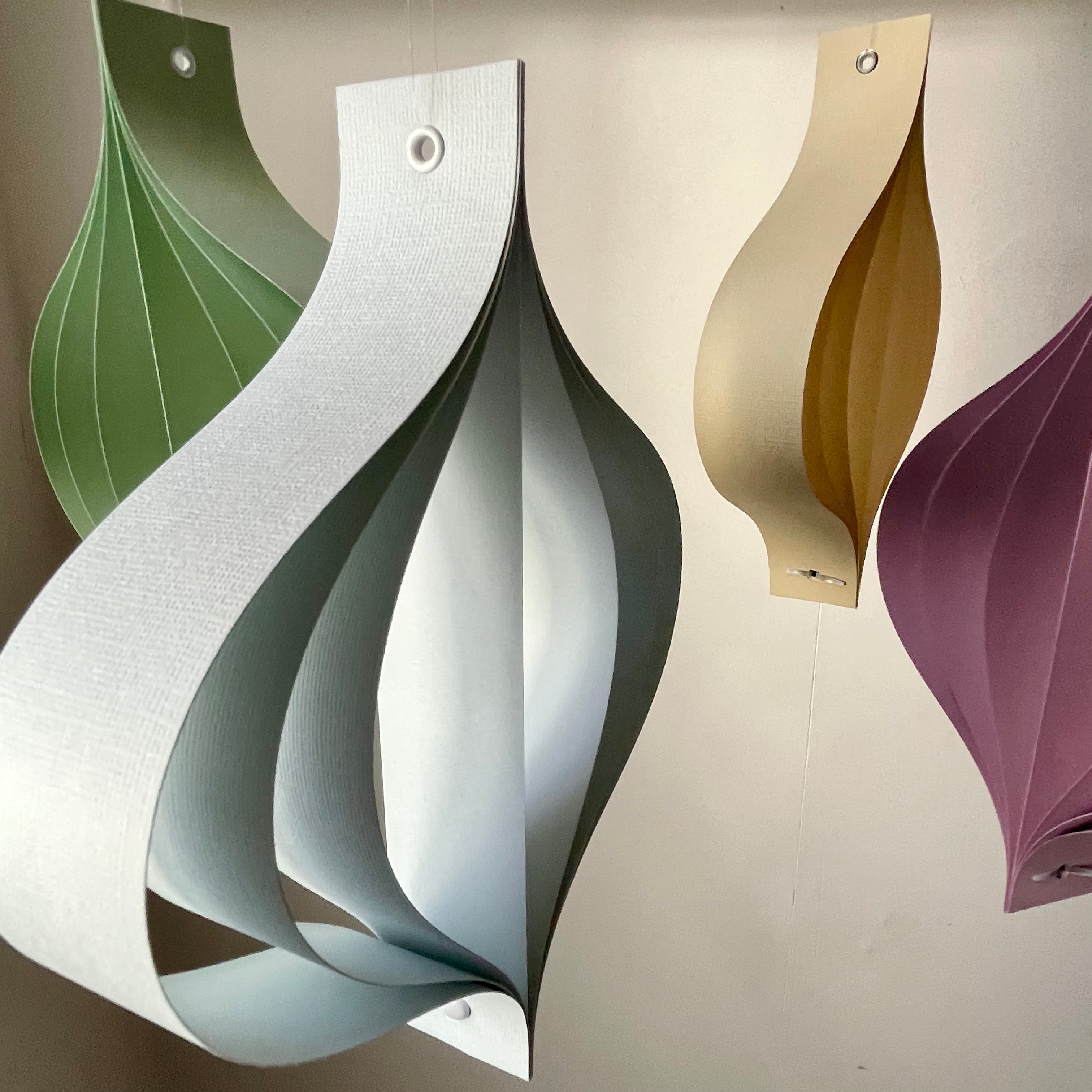 Pastel home ornaments in dusty pastel tones of green, yellow, beige, blue and purple on a neutral background