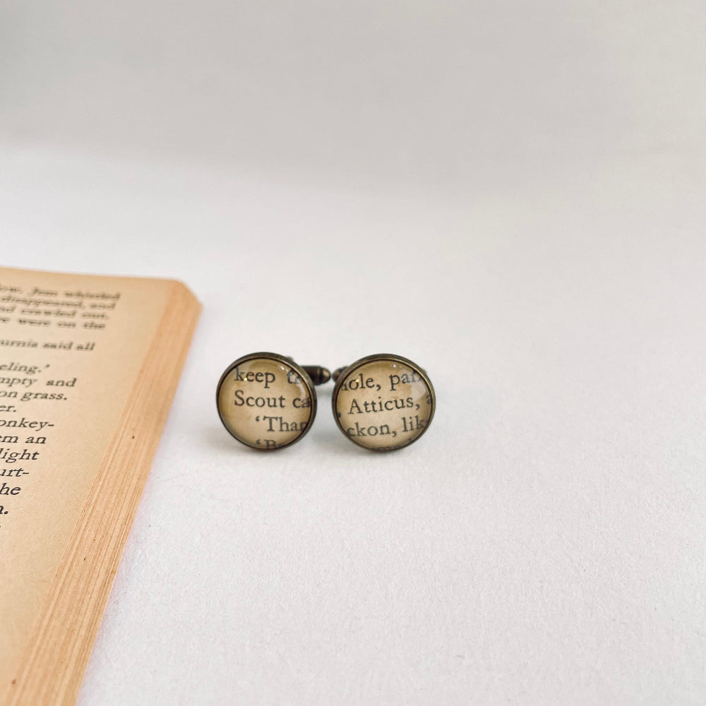 Cufflinks with text on a book page showing scout and atticus finch