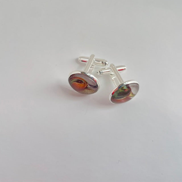silver round cufflinks with an illustration of a duck, taken from a bird identification book