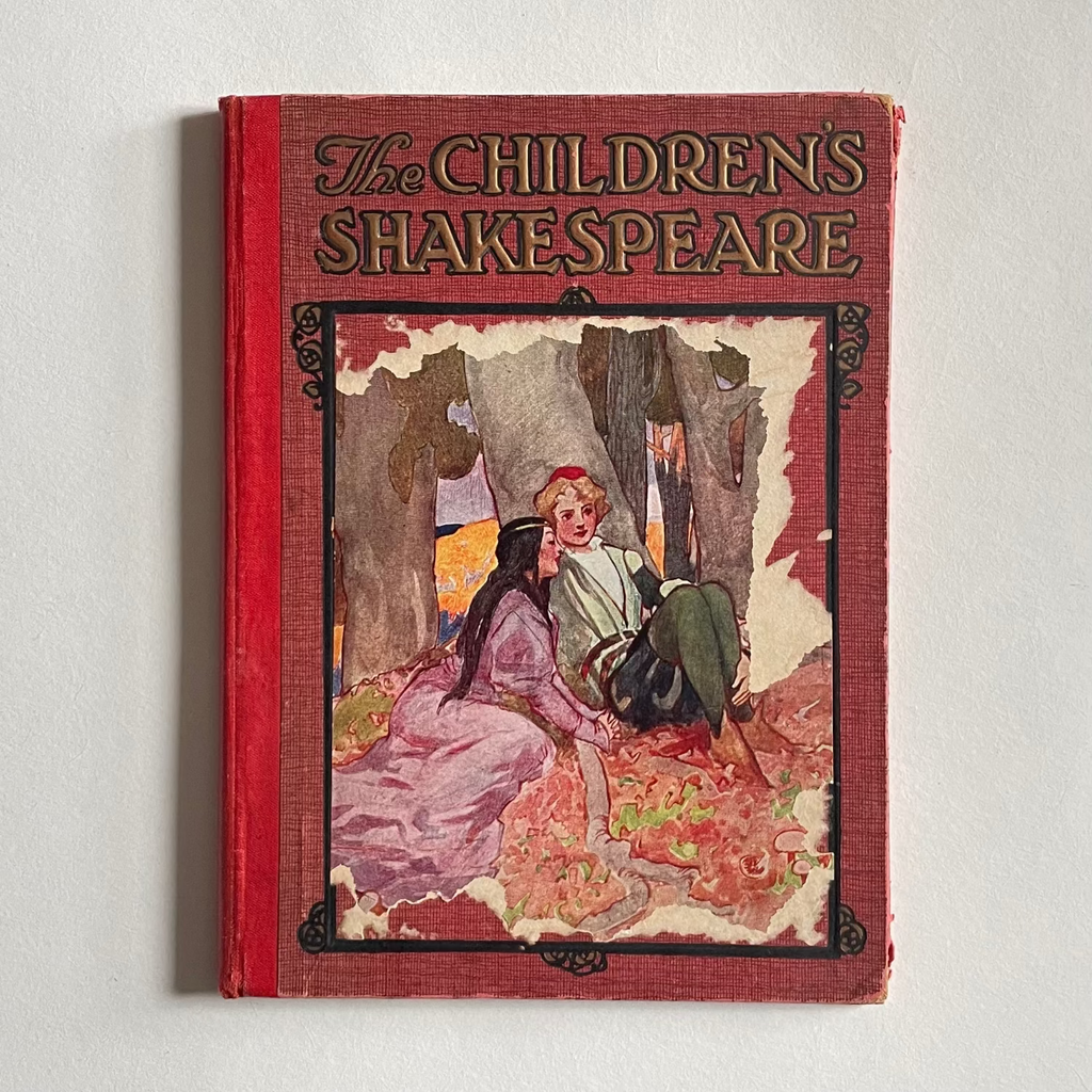 Book titled 'The Children's Shakespeare' with a red cover and illustration of two characters on a white background